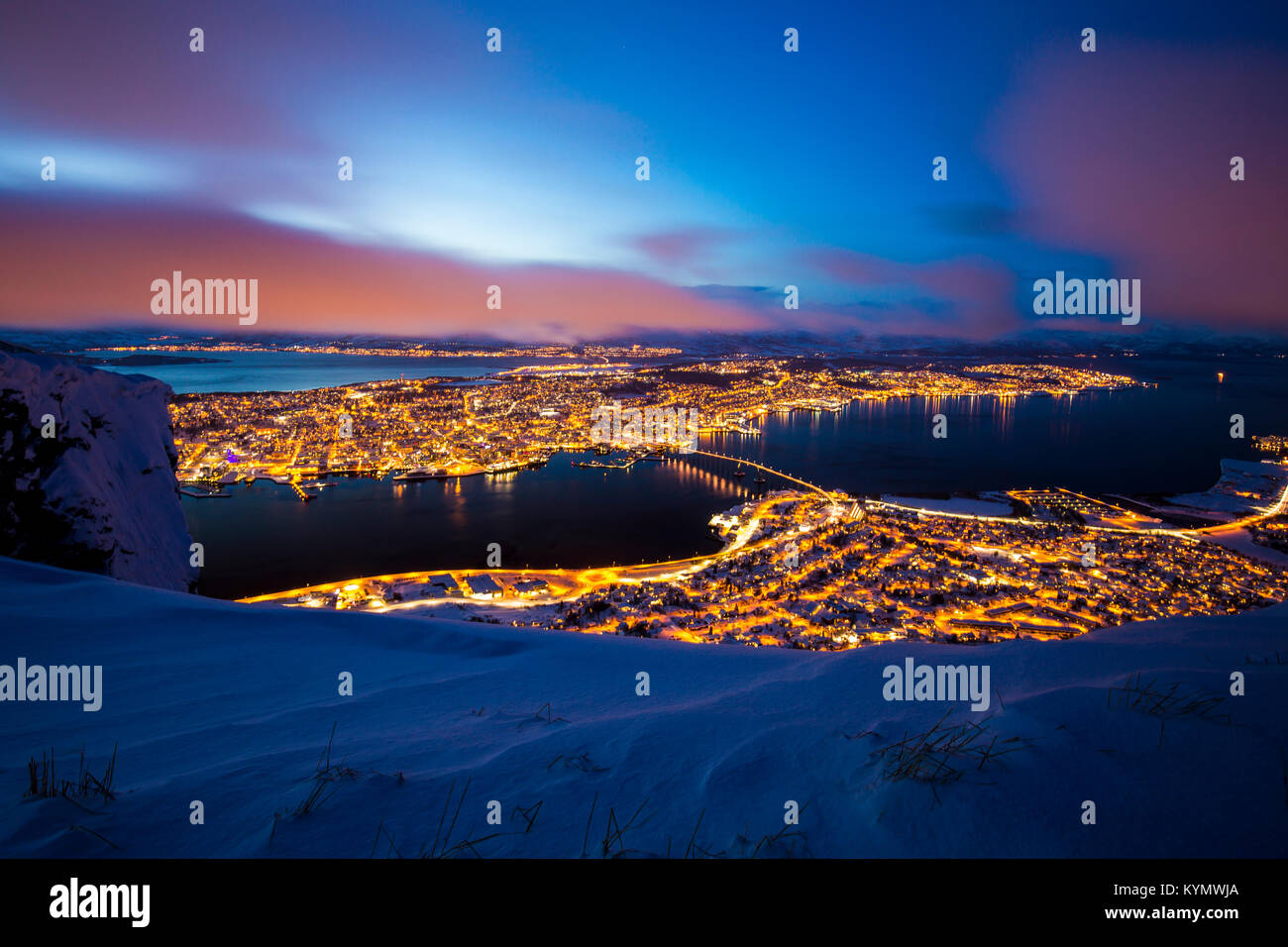 Schöne und bunte Luftaufnahme auf die Stadt Tromsø, Troms Norwegen, während der Dämmerung. Ein Winter Schneesturm ist eingehende im Tal von Tromsø, beseitigen Stockfoto