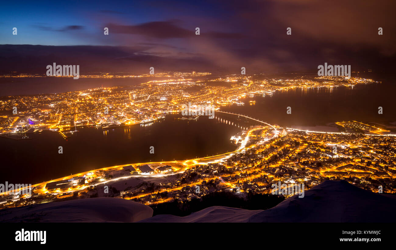 Schöne und bunte Luftaufnahme auf die Stadt Tromsø, Troms Norwegen, während der Dämmerung. Ein Winter Schneesturm ist eingehende im Tal von Tromsø, beseitigen Stockfoto