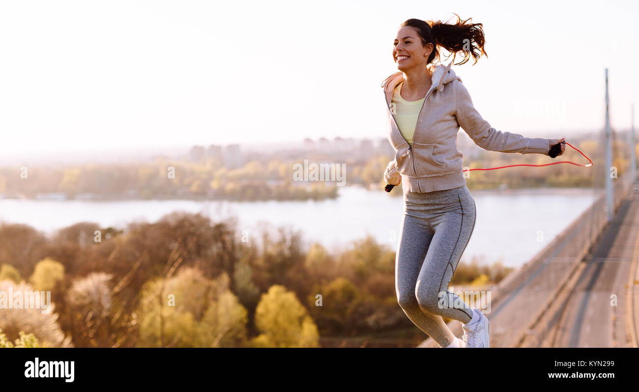 Aktive Frau springen mit Springseil im Freien Stockfoto