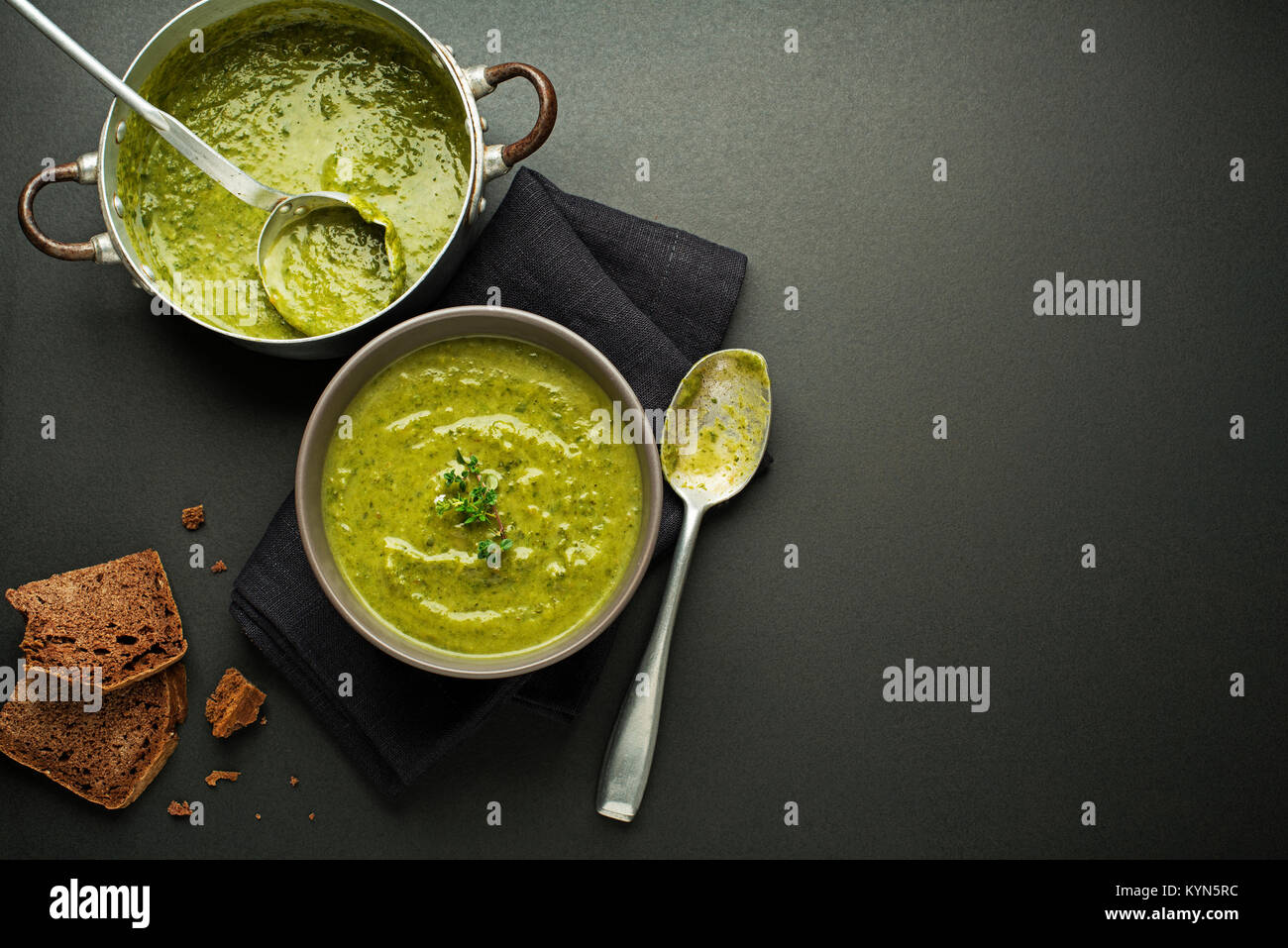 Frische, gesunde grüne Suppe auf schwarzem Hintergrund overhead zu schießen. Stockfoto