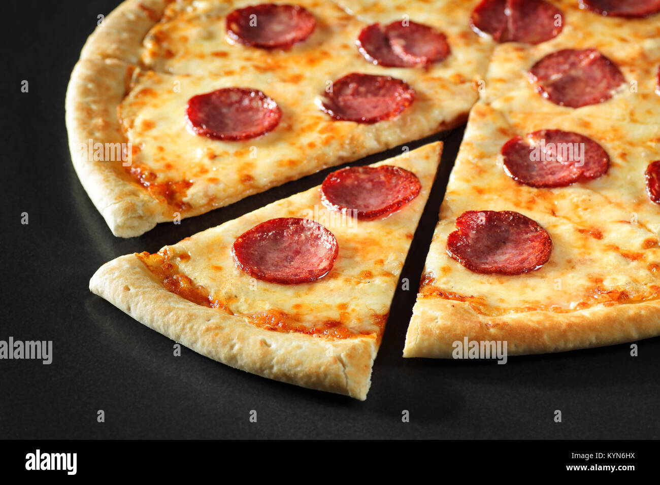 Cut Pizza aus der Nähe Peperoni auf schwarzen Stein Hintergrund Stockfoto