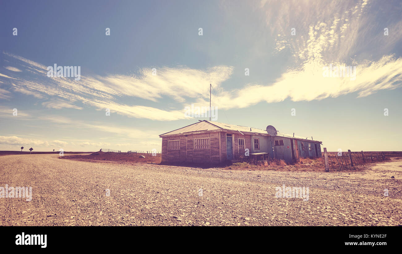Verlassenes Haus durch eine Schotterstraße, Farbe getonte Bild, Patagonien. Stockfoto Verlassenes Haus durch eine Schotterstraße, Farbe getonte Bild, Patagonien. Stockfoto