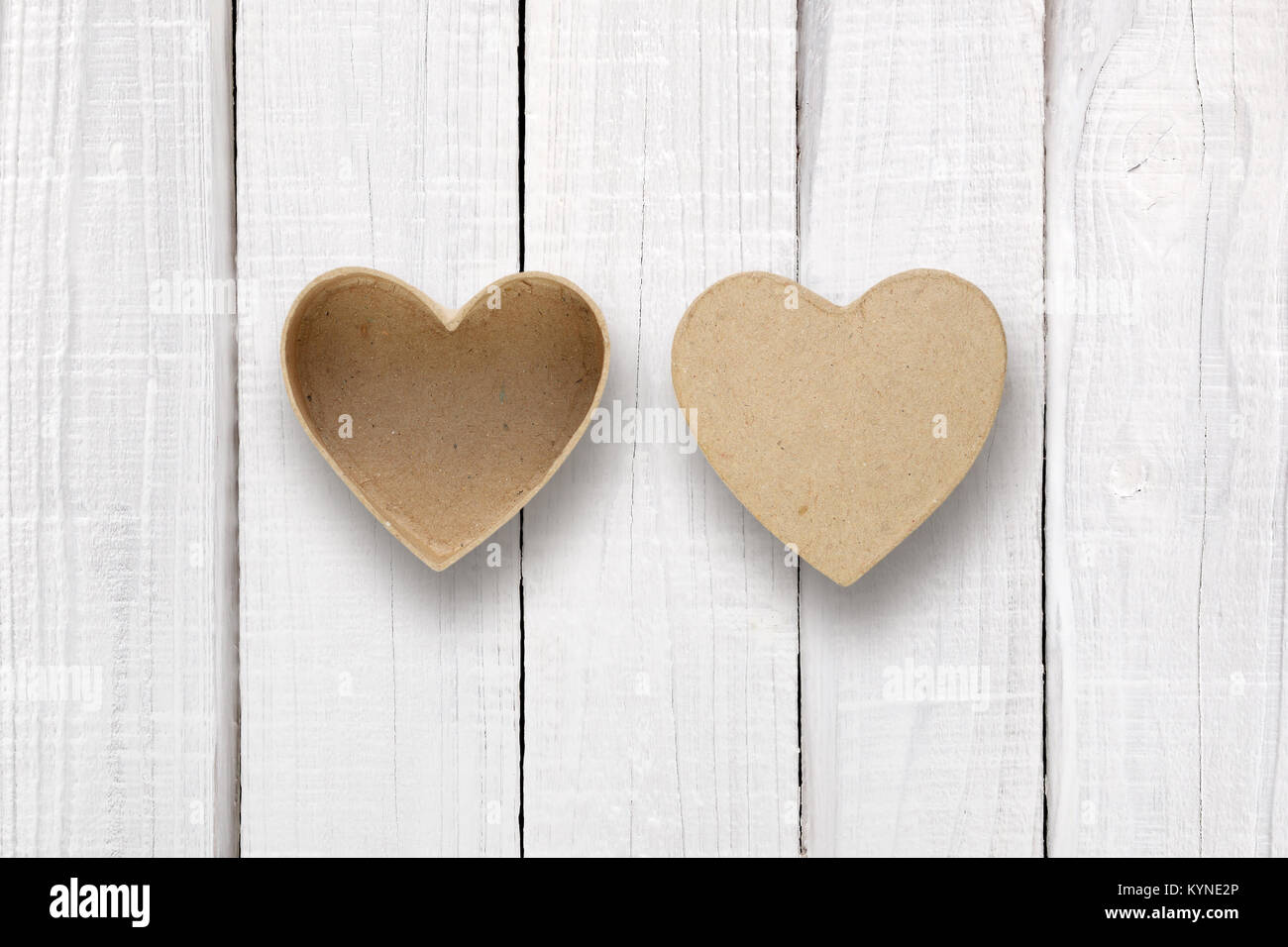 Leere Box mit Deckel in der Form von Herzen auf weissem Holztisch Stockfoto