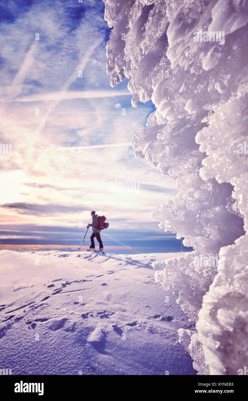 Eisformationen mit Langläufer Silhouette in Abstand bei Sonnenuntergang, Farbe getonte Bild, Nationalpark Riesengebirge, Polen. Stockfoto