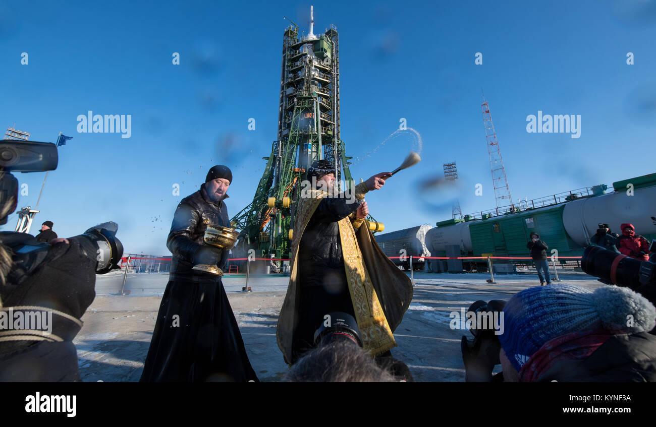 Ein orthodoxer Priester segnet die Mitglieder der Medien im Kosmodrom Baikonur Startrampe am Samstag, den 16. Dezember, 2017. Expedition 54 Sojus Kommandant Anton Shkaplerov von Roskosmos, bordingenieur Scott Kribbeln der NASA, und Flugingenieur Norishige Kanai der Japan Aerospace Exploration Agency (JAXA) sind geplant, um die Internationale Raumstation an Bord der Sojus-Kapsel vom Kosmodrom Baikonur zu am 04.12.17. Photo Credit: (NASA/Joel Kowsky) Stockfoto