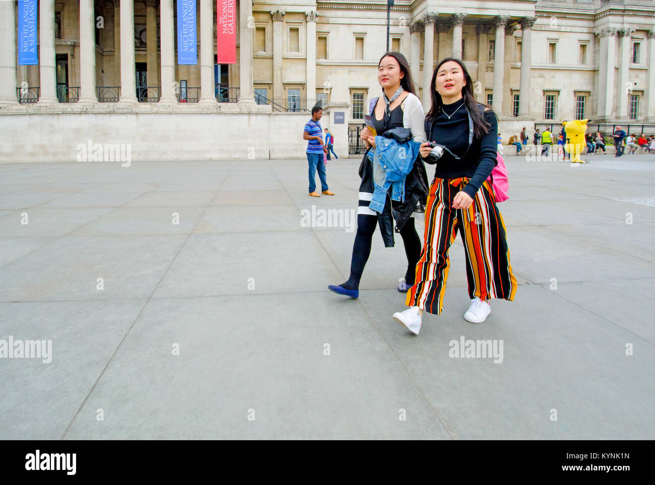 London, England, UK. Zwei asiatische Touristen und Geschäftsreisende, die National Gallery, der Trafalgar Square Stockfoto