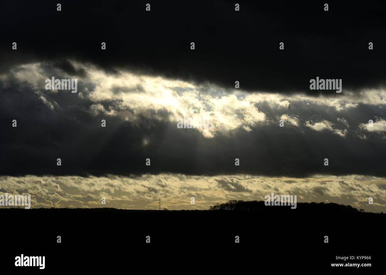 Die Sonne scheint durch die dunklen Wolken, die in der Nähe von Corby, Northamptonshire, auf was behauptet wird der traurigste Tag des Jahres zu sein. Stockfoto