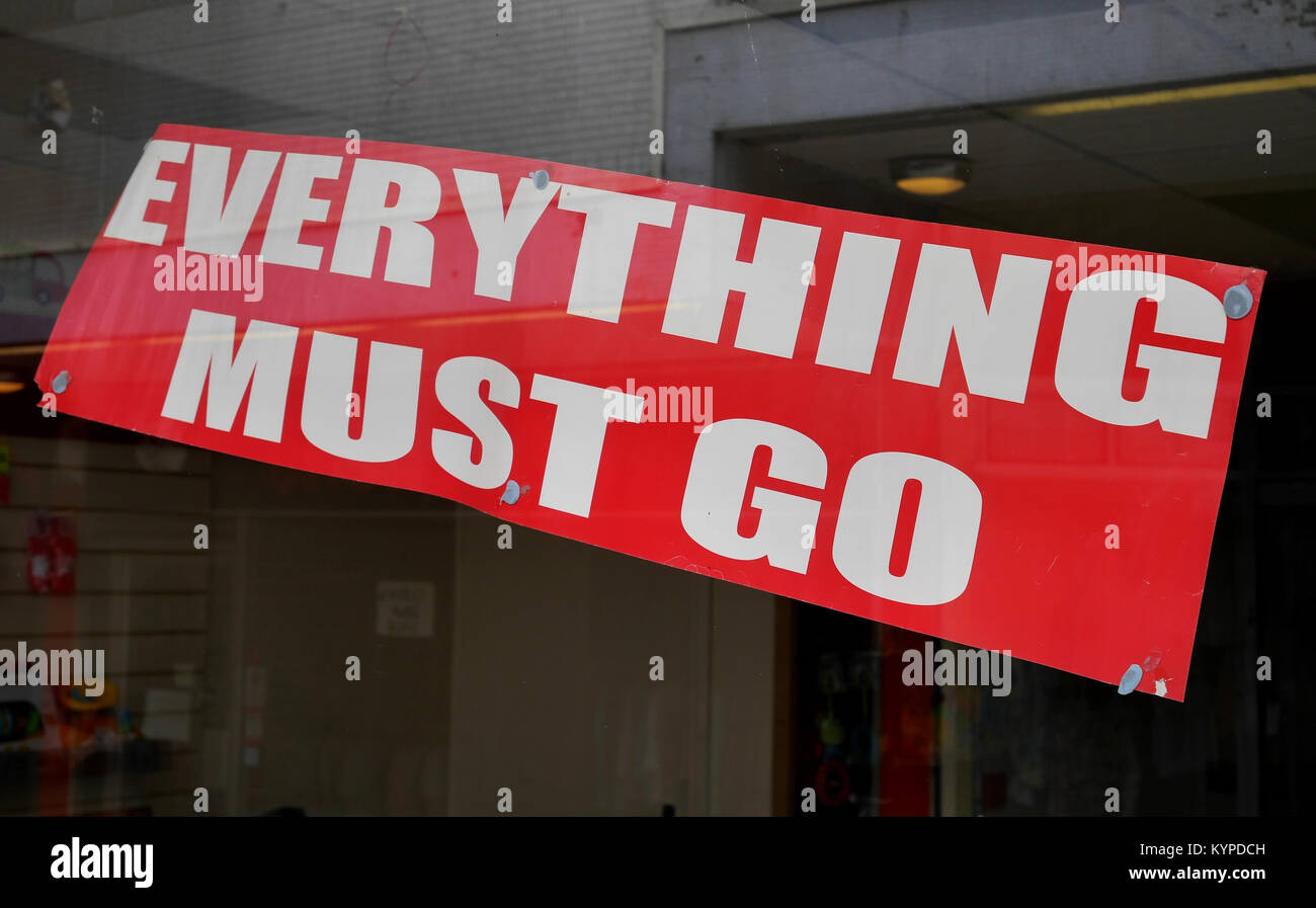 Rote "Alles muss gehen", Schild im Fenster der Geschlossen retail business in verlassenen Shopping Precinct, quer Einkaufszentrum, Torquay, Devon, Großbritannien Stockfoto