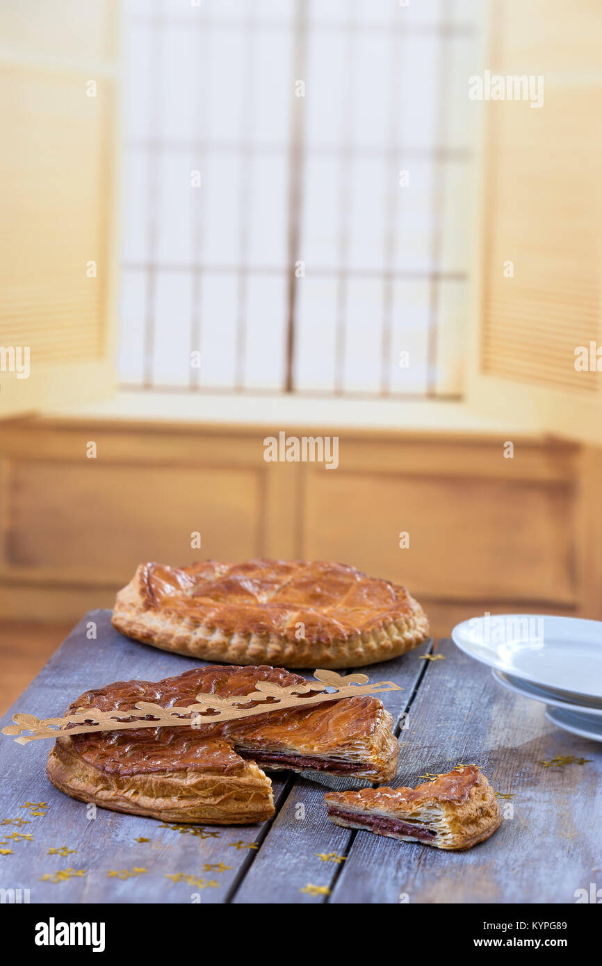 Galette des Rois Kuchen. Traditionelle französische Epiphanie Kuchen mit Mandeln auf grau Holzbrett gegen Fenster Hintergrund. Stockfoto