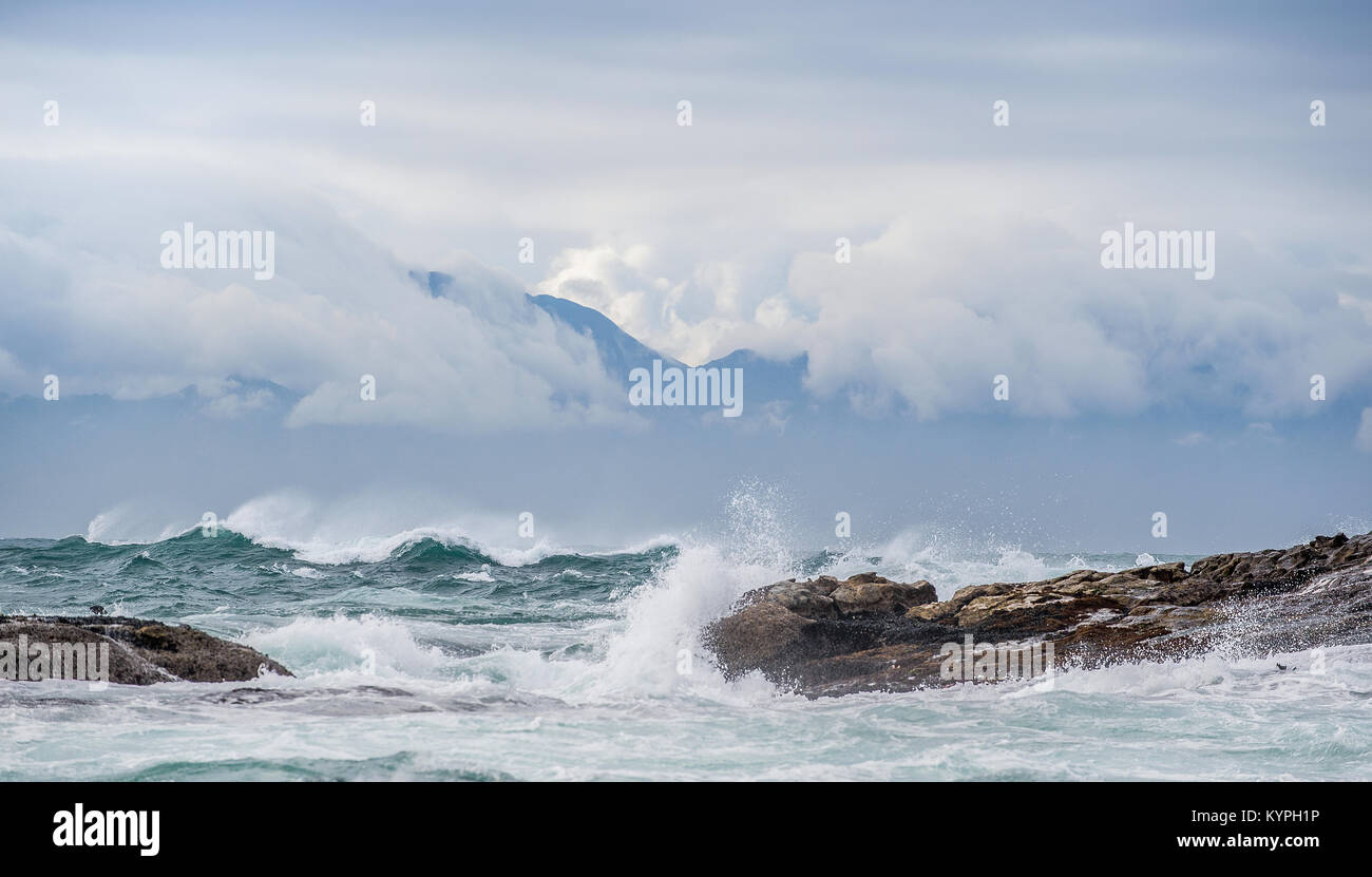 Meer Landschaft. Wolken Himmel, Wellen mit Spritzern, Berge Silhouetten. Die False Bay. Südafrika. Stockfoto