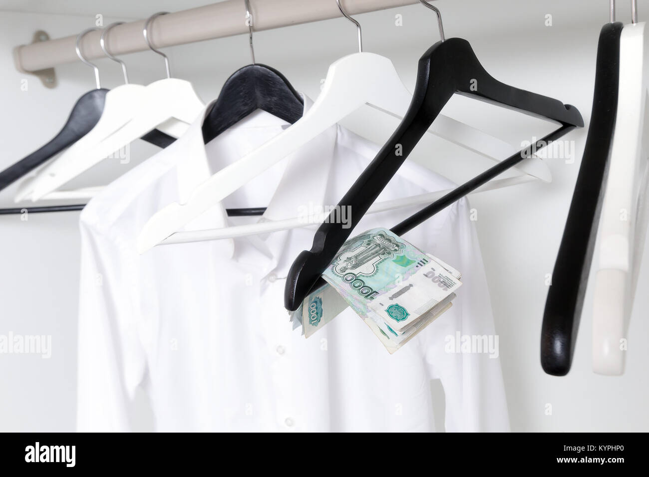 Russische Rubel und leere Kleiderbügel im Schrank Stockfoto