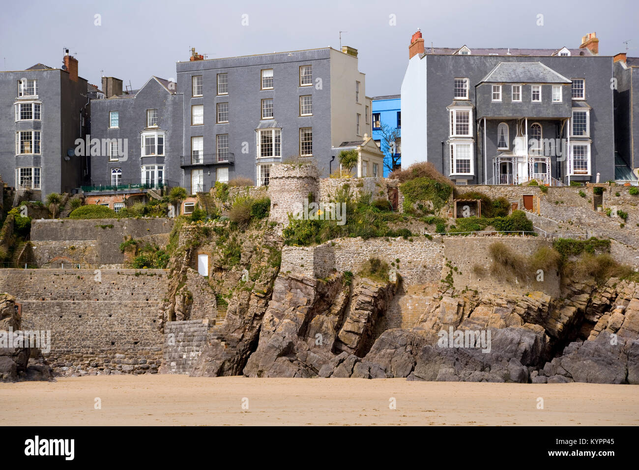 Eine lebendige blau lackiert Haus sticht unter grauen Häusern auf den Klippen, Tenby, Pembrokeshire, Wales, Großbritannien Stockfoto