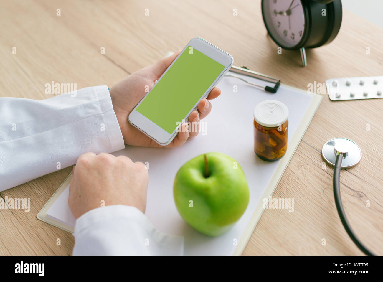Arzt apple Beratung statt Pillen und Antibiotika, weibliche Hand in weißen Mantel Holding mit samrtphone blacnk Mock up Bild als Kopie Raum Stockfoto