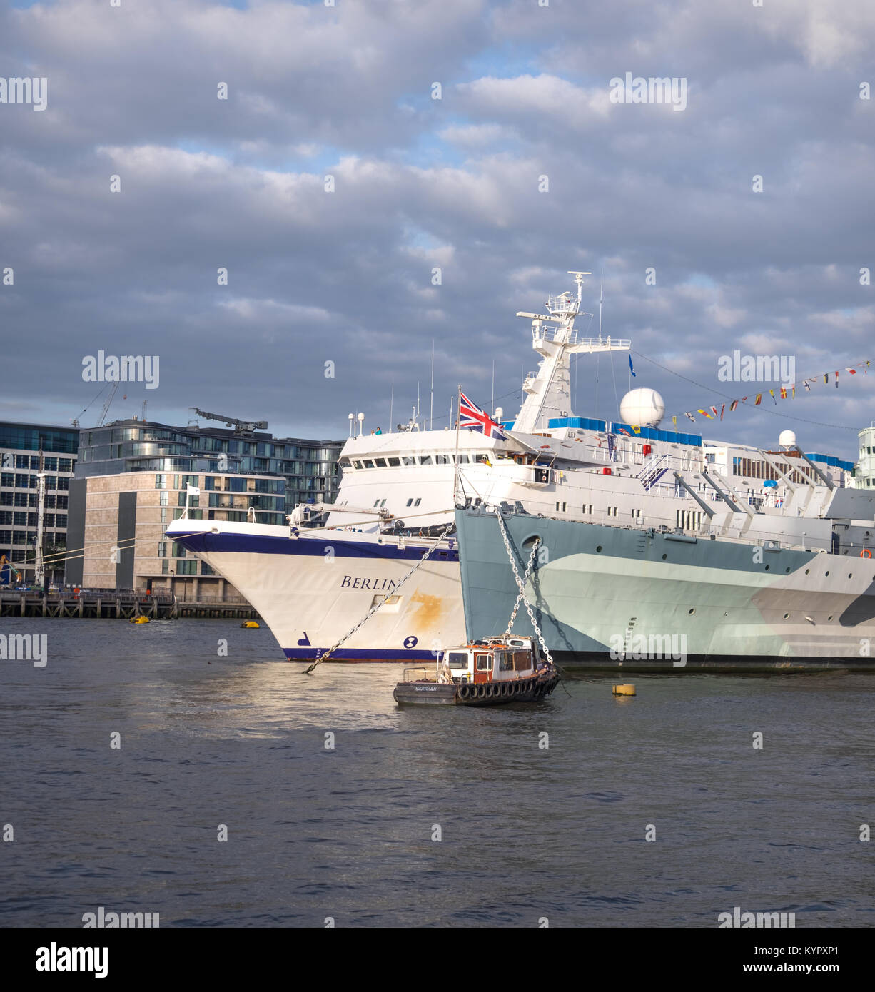 LONDON, Großbritannien - 9. Mai 2015: Passenger (Cruise) Ship 'Berlin' neben 'HMS Belfast Auf der Themse unter dramatischen Himmel. Panoramablick auf das Bild. Stockfoto