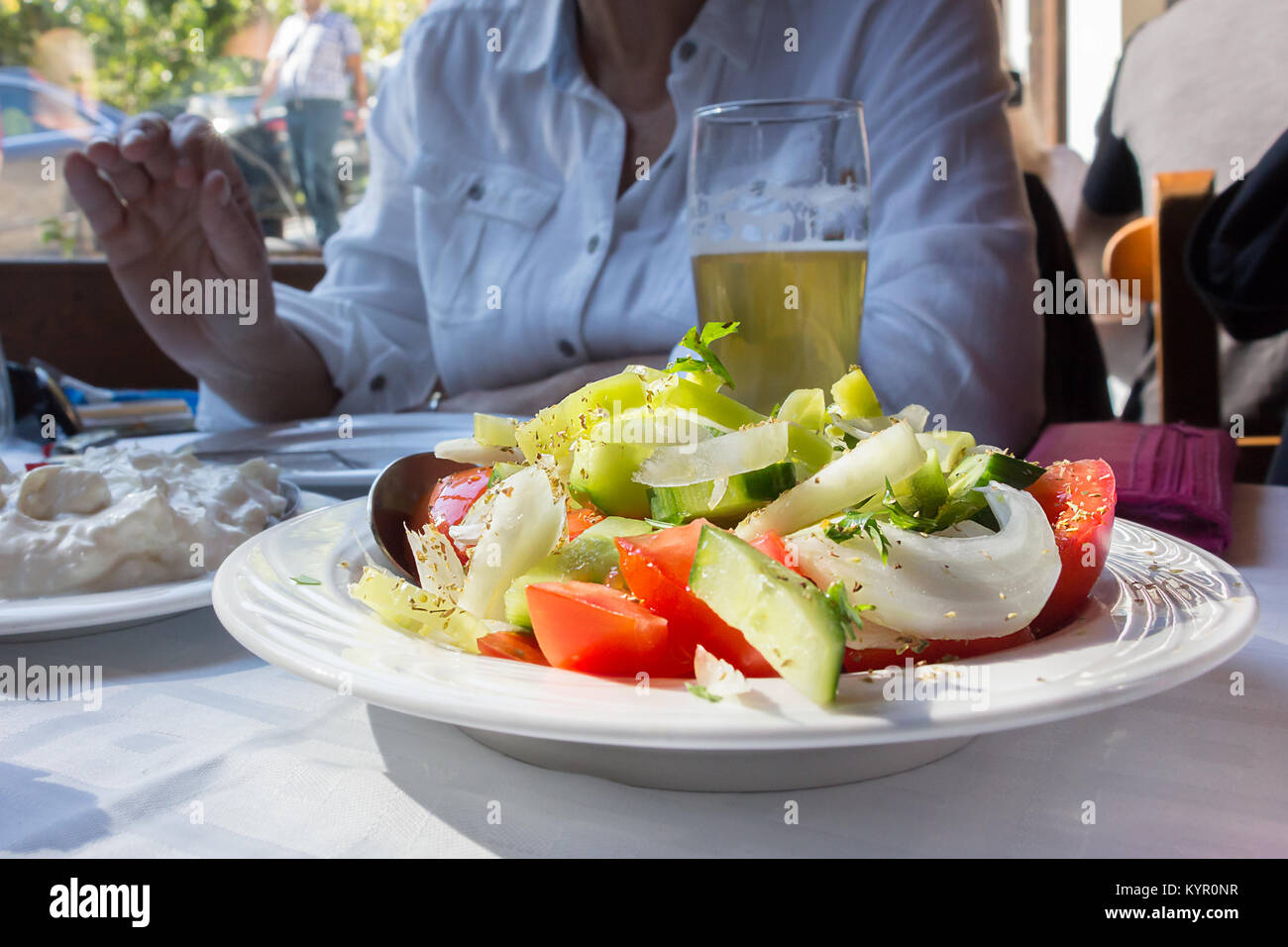 Nahaufnahme eines griechischen traditinal Salat mit Tomaten, Zwiebeln, Oregano und Gurke auf eine Tabelle innerhalb einer Taverne in Griechenland. Stockfoto