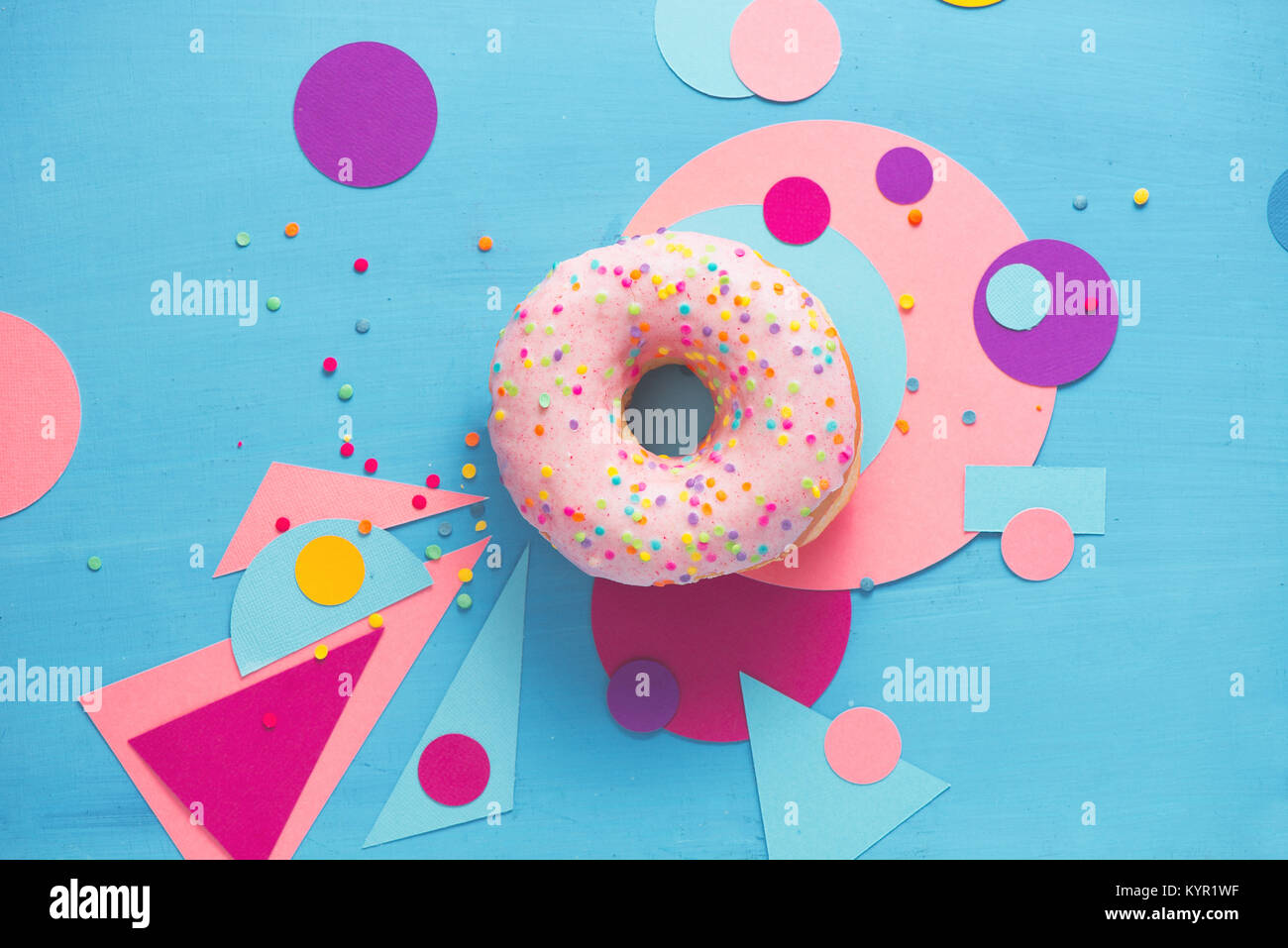 Rosa glasierten Krapfen auf einem farbigen Hintergrund mit geometrischen Formen. Farbe Block essen Fotografie. Stockfoto