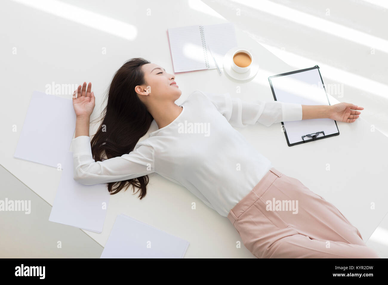 Junge Geschäftsfrau schlafen auf dem Schreibtisch Stockfoto