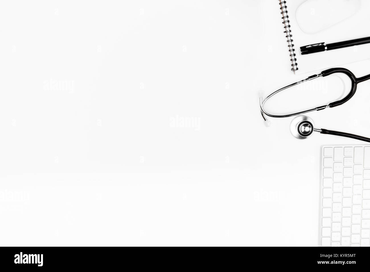 Flach mit Stethoskop, Tastatur und Notebook mit Pen isoliert auf weißem Stockfoto