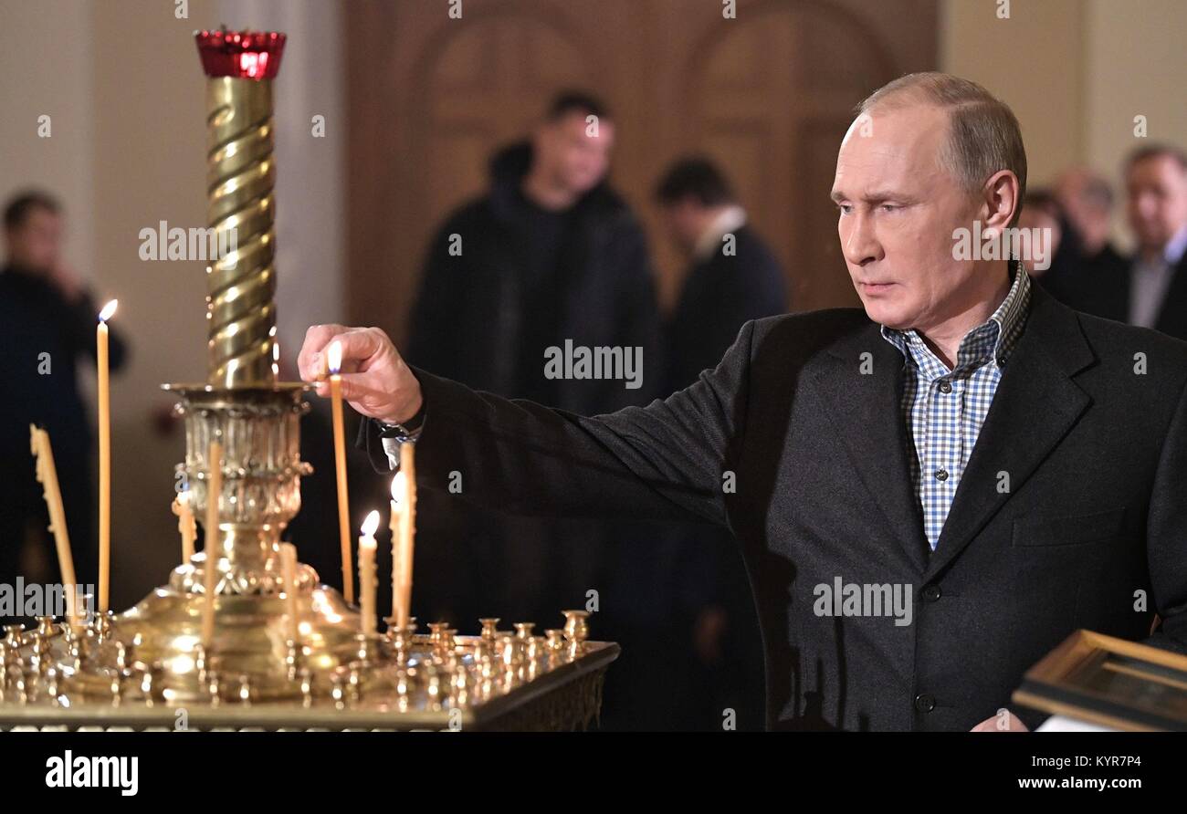 Der russische Präsident Wladimir Putin eine Kerze leuchtet während der Russisch-orthodoxen Messe Weihnachten in der Kirche von St. Simeon und Anna Januar 7, 2018 in St. Petersburg, Russland feiert. Stockfoto