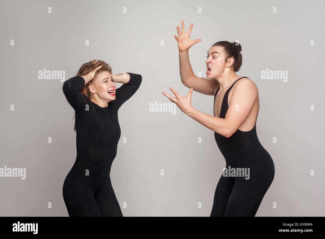 Streit im Paar. Zornigen Mann anschreien, jungen erwachsenen Frau. Studio shot, auf grauem Hintergrund Stockfoto