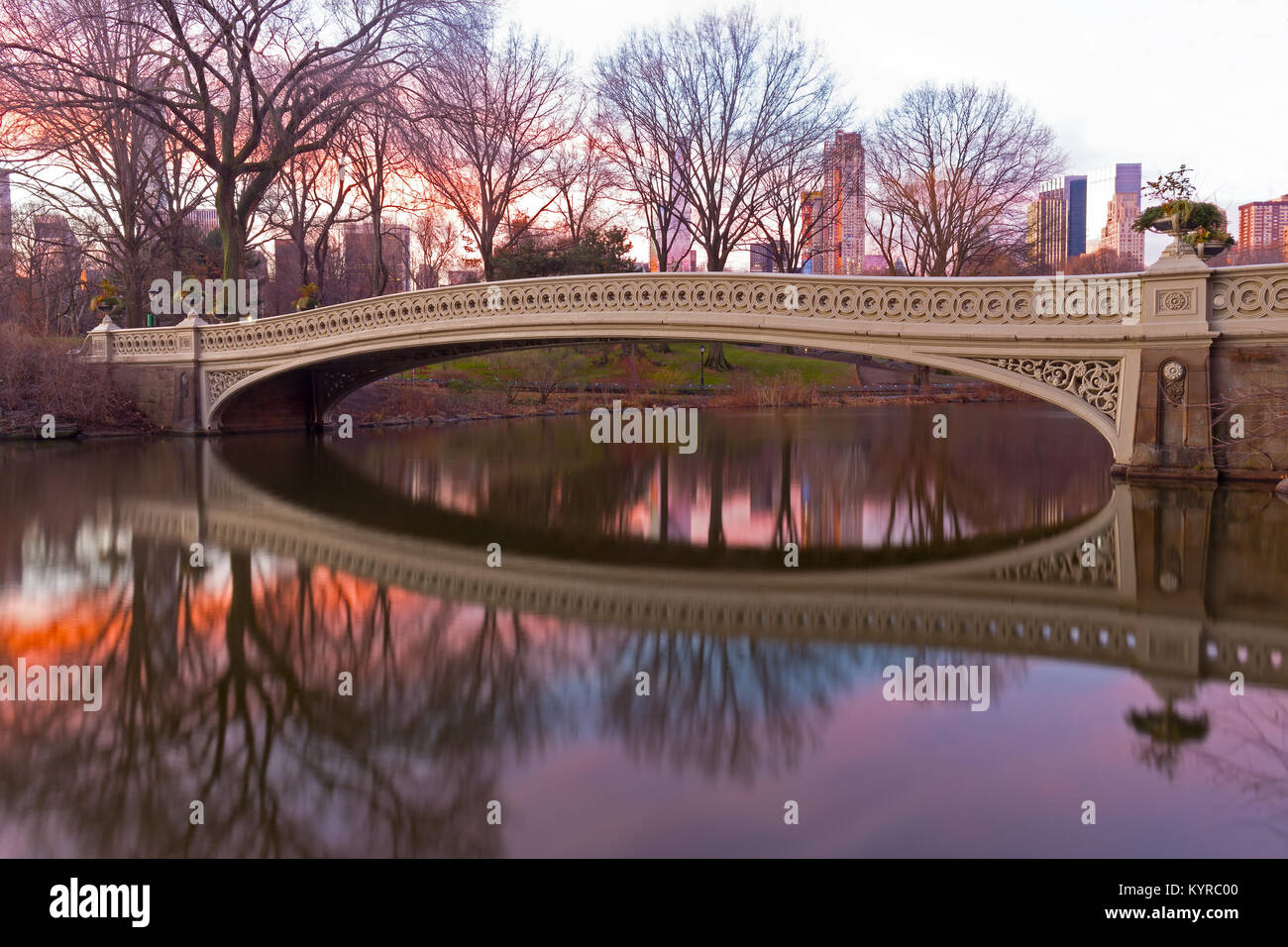 Der Bogen Brücke an schönen Winter Sonnenaufgang im Central Park, New York City. Der größte Park Bridge mit Reflexion durch das Einpflanzen von Urnen eingerichtet. Stockfoto