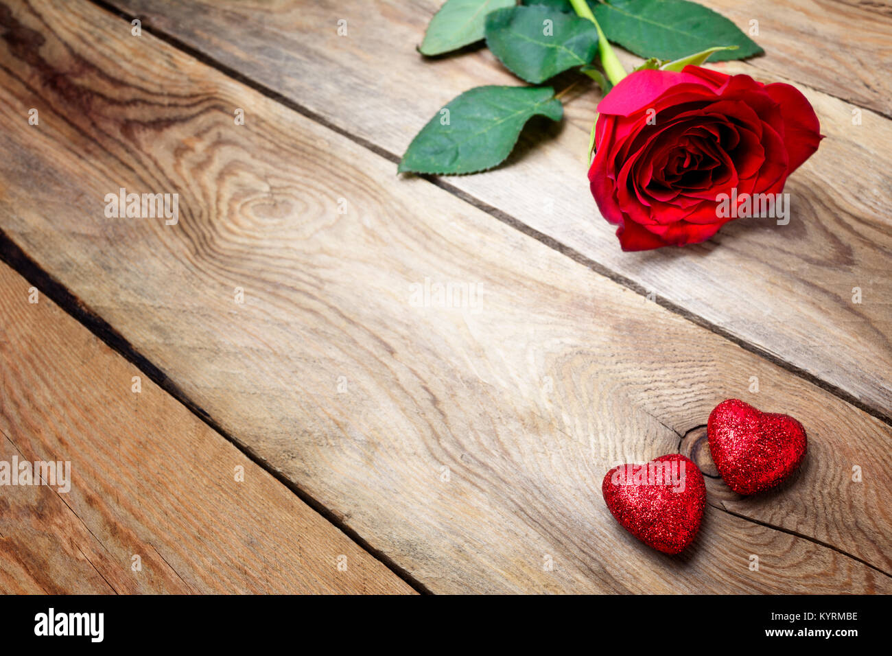 Valentinstag Grußkarten mit rote Rose und zwei Glitter Herz auf die alten hölzernen Hintergrund, kopieren. Stockfoto