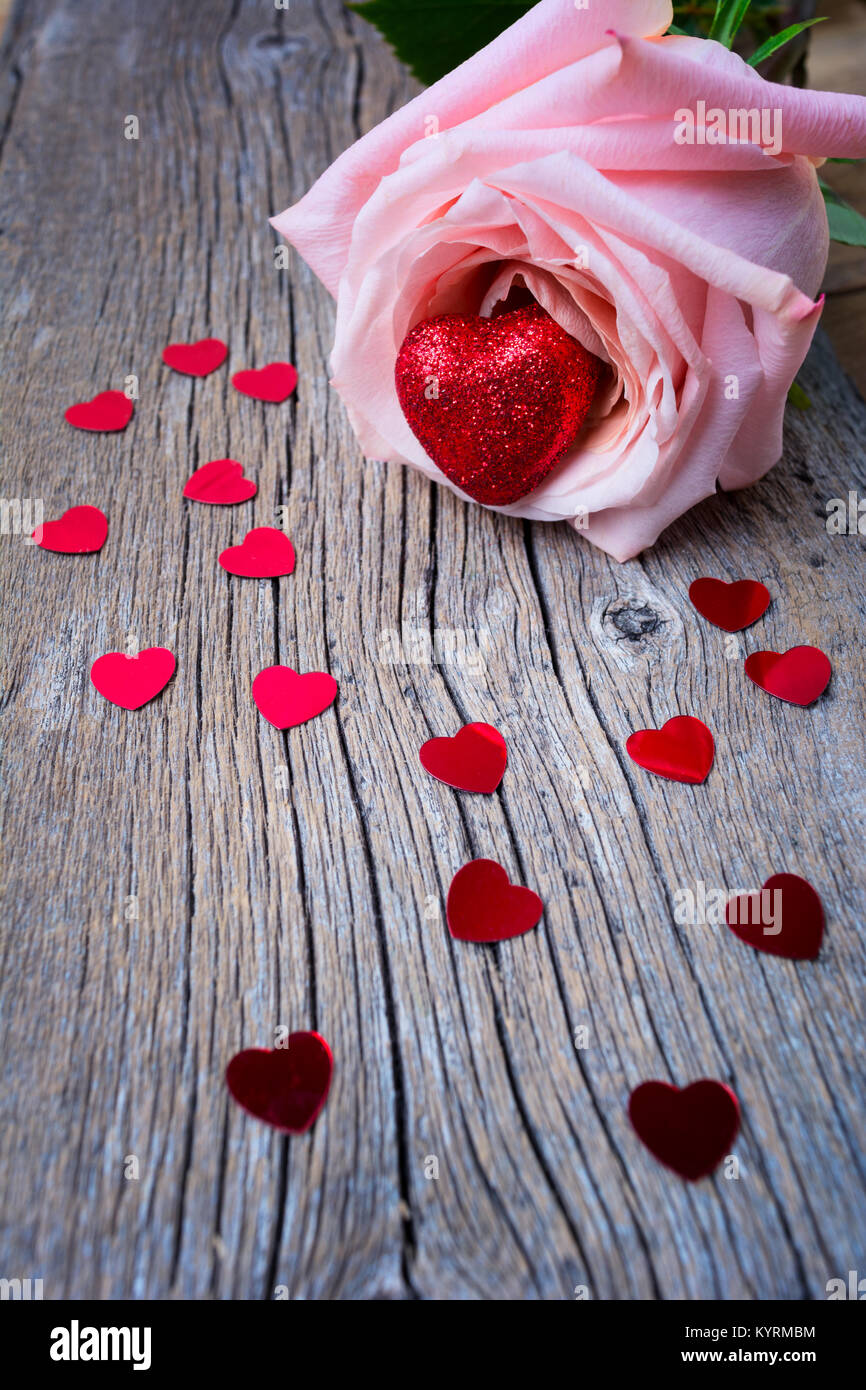 Valentines Tag Begrüßung mit rosa Rosen und Herzen auf dem verwitterten Holz- Hintergrund Stockfoto