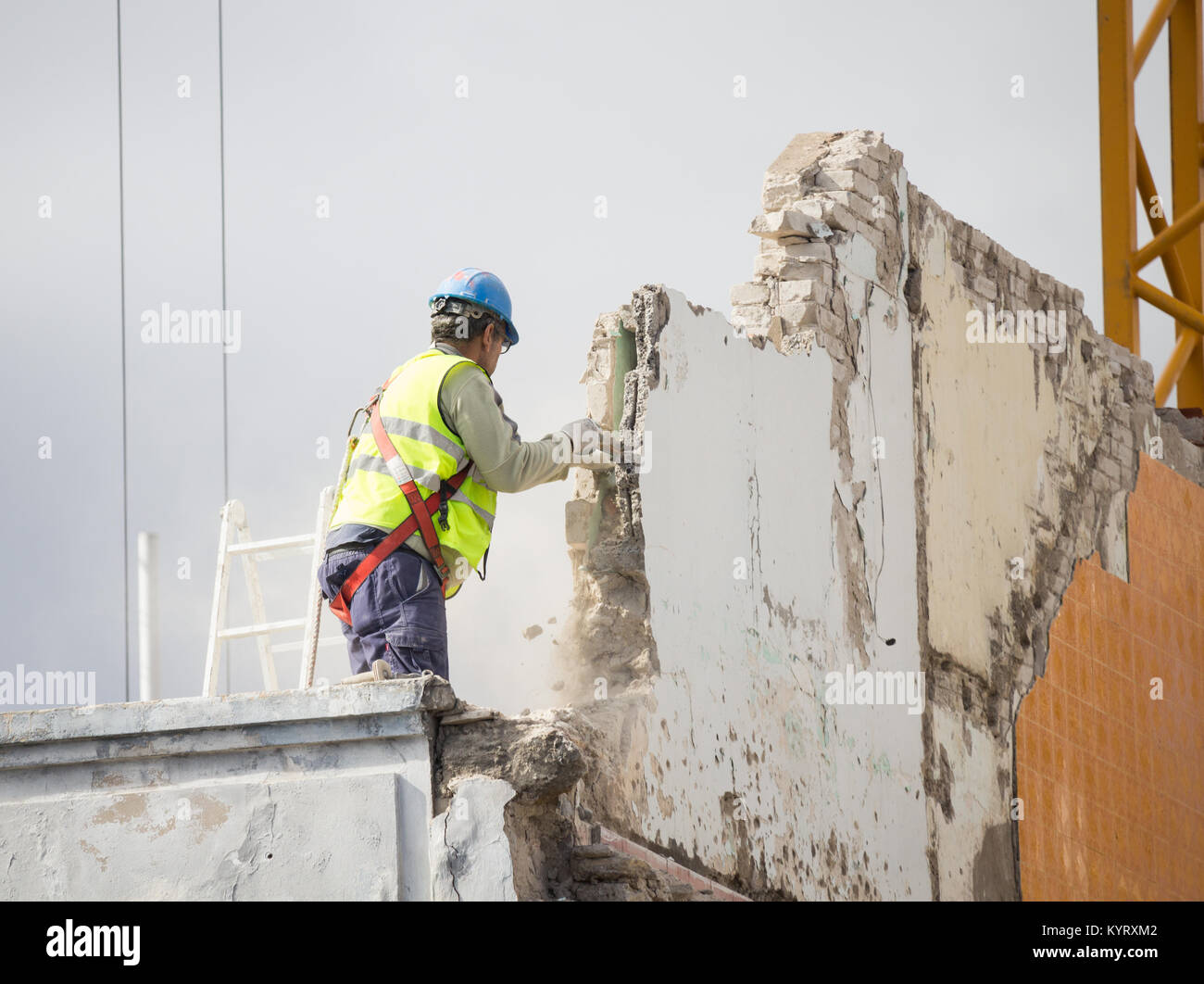 Handwerker demolieren Wand auf hohe Gebäude ohne Sicherheit am Kabelbaum angeschlossen werden. Stockfoto