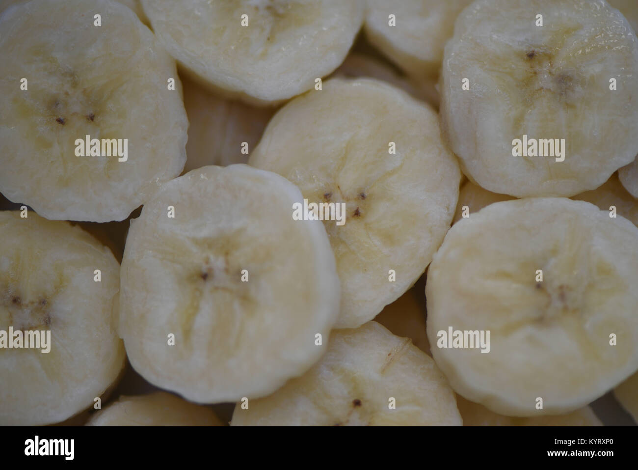 Nahaufnahme makro Food Fotografie der gesunden frisches Obst von Bananen in Scheiben von gelber Farbe und füllt das Bild für eine Zusammenfassung Hintergrund Stockfoto