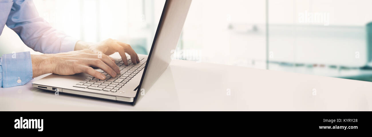 Moderne Geschäftsmann Tippen auf Laptop Tastatur im hellen, sonnigen Büro. Copyspace Stockfoto