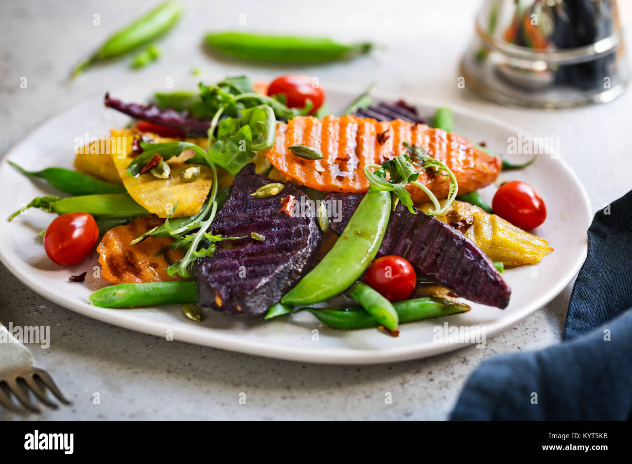 Gegrillte Süßkartoffeln mit Snap Erbse, Kirschtomaten und Rucola Stockfoto