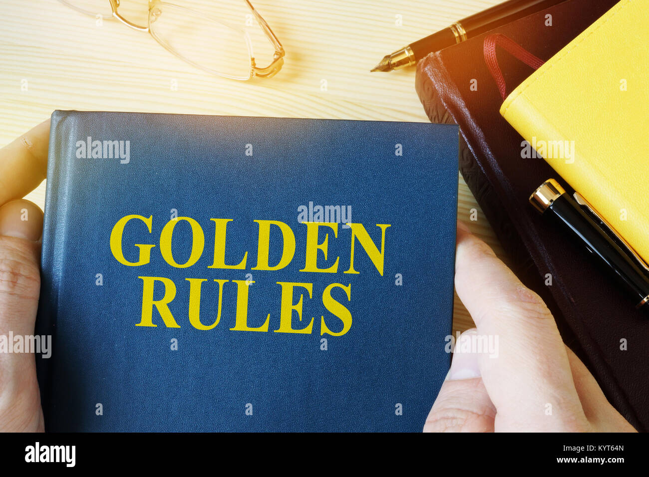 Mann hält Guide mit Titel goldene Regeln. Stockfoto