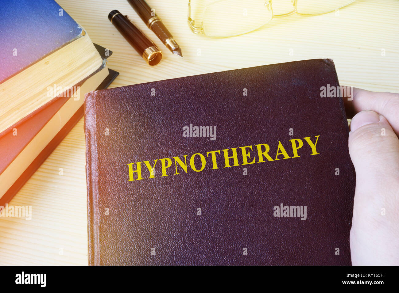 Mann, Buch mit Titel Hypnotherapie. Stockfoto