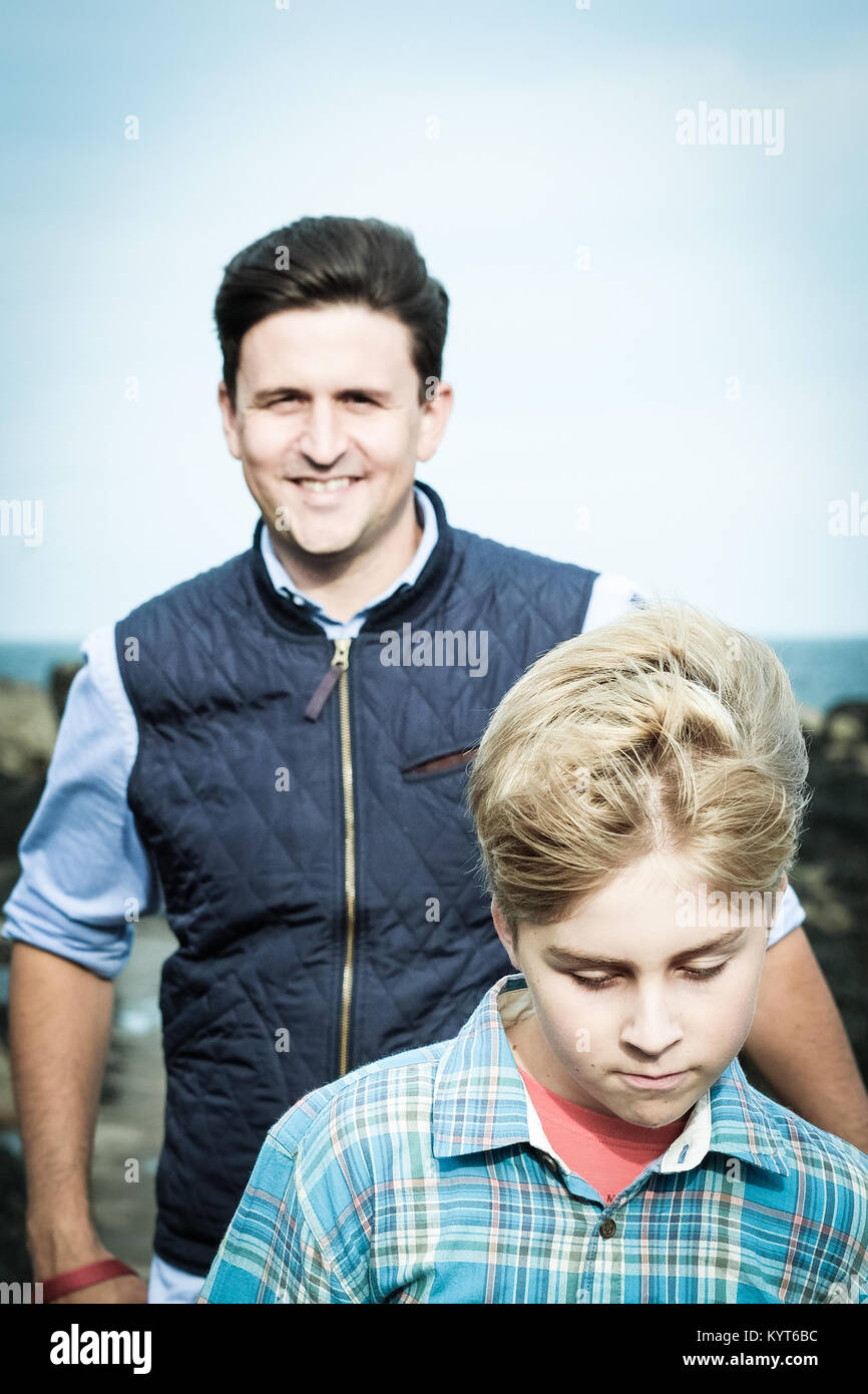 Vater und Sohn gehen durch das Meer in die Bucht [Songbook], Yorkshire, Großbritannien Stockfoto