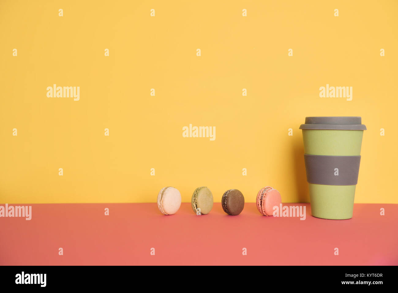 Tasse Kaffee mit Macaron auf gelb und rosa Hintergrund gehen Stockfoto