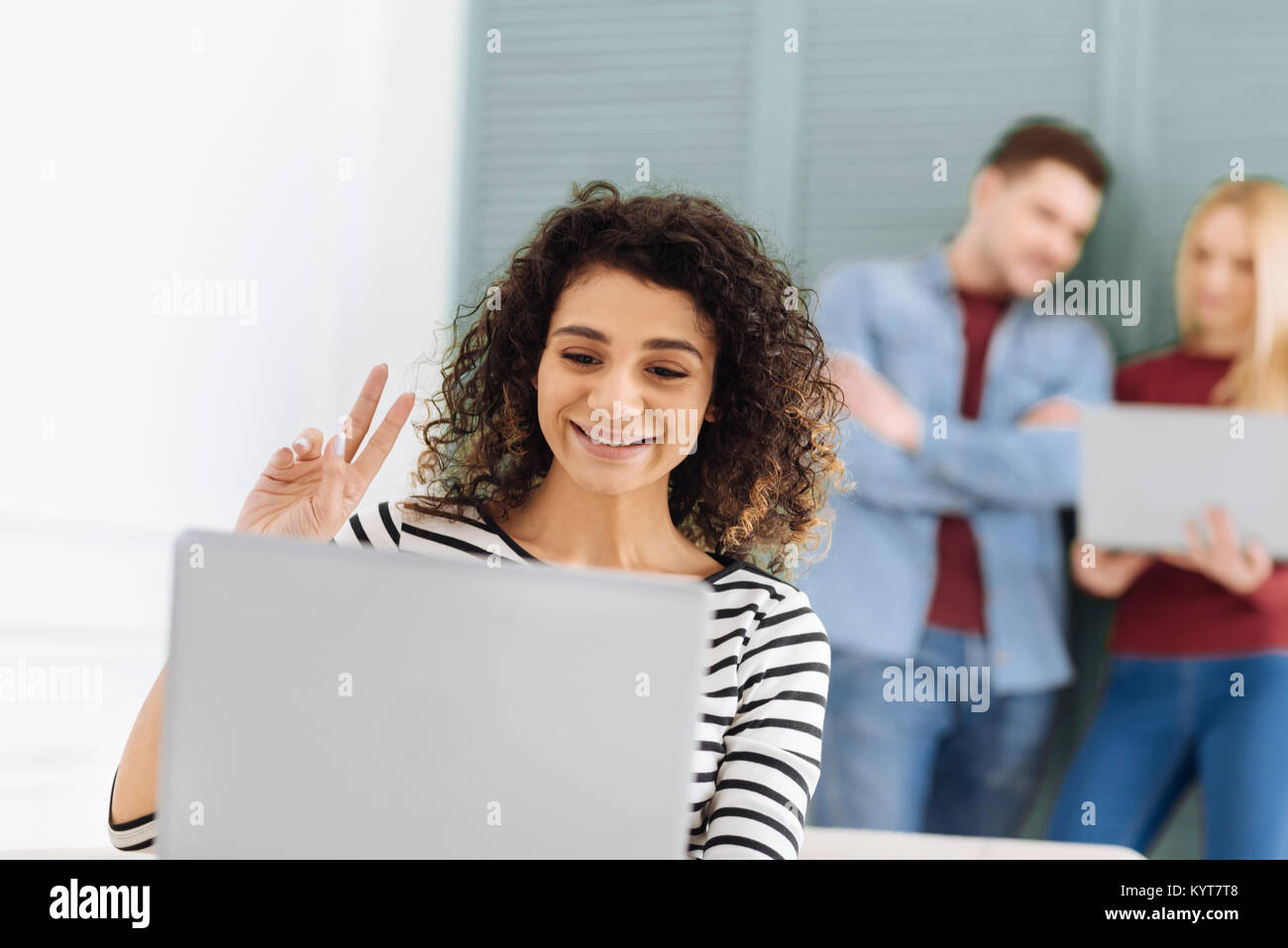 Lustig Mädchen mit lockigem Haar in Videokonferenz Stockfoto