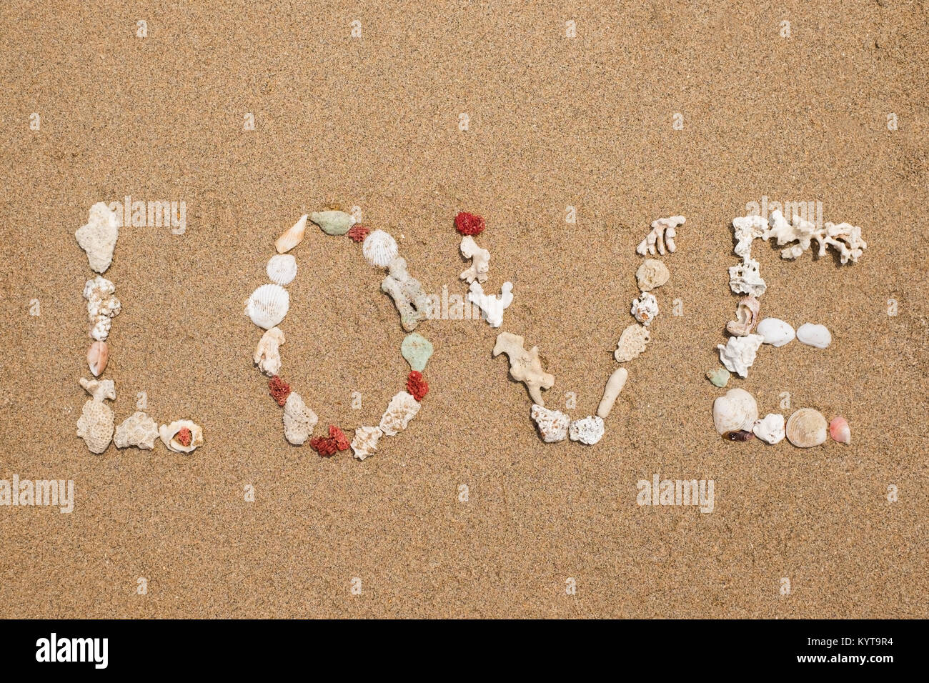 Inschrift Liebe von Muscheln auf Sand Stockfoto