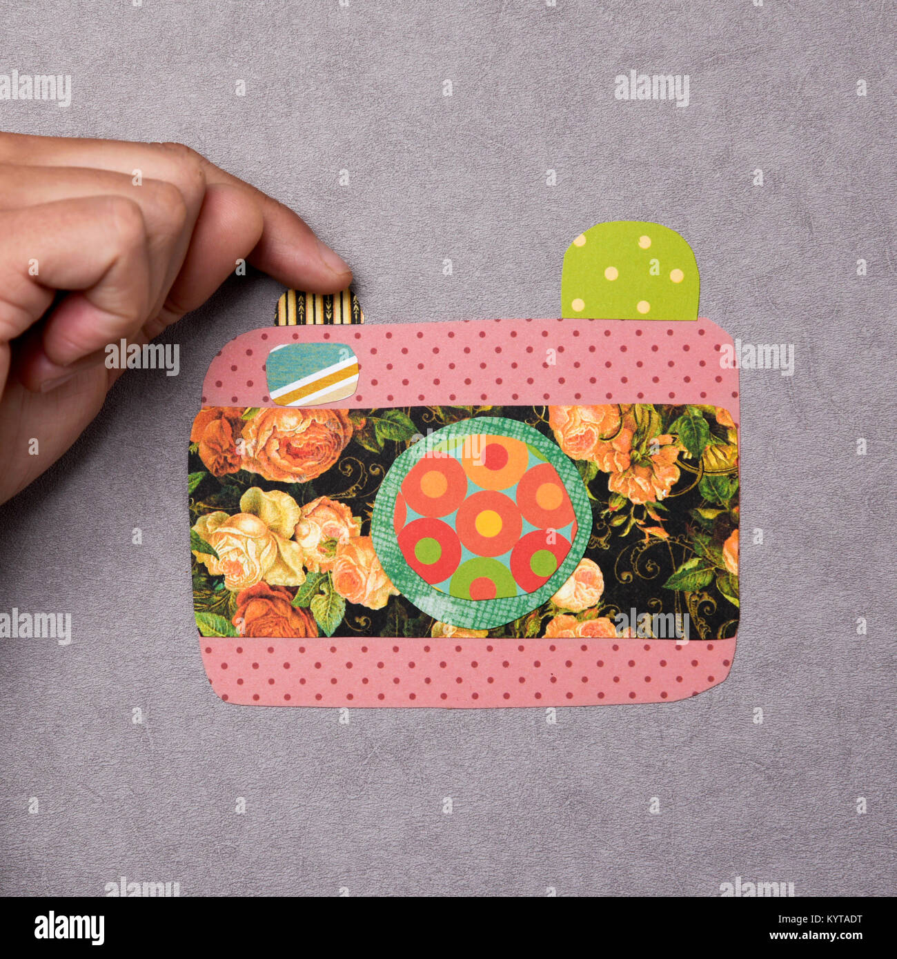 Nahaufnahme von einem Mann schießen eine gefälschte Kamera mit Ausschnitten aus Papier in verschiedenen Farben und Mustern gemacht Stockfoto