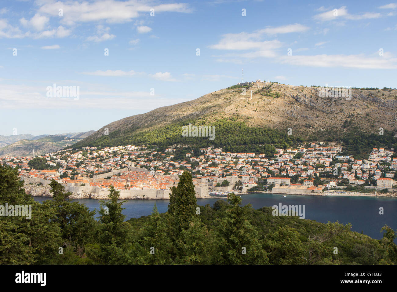 Gebäude auf dem Hügel und Berg Srd in Dubrovnik, Kroatien, gesehen von der grünen Insel Lokrum an einem sonnigen Tag. Kopieren Sie Platz. Stockfoto