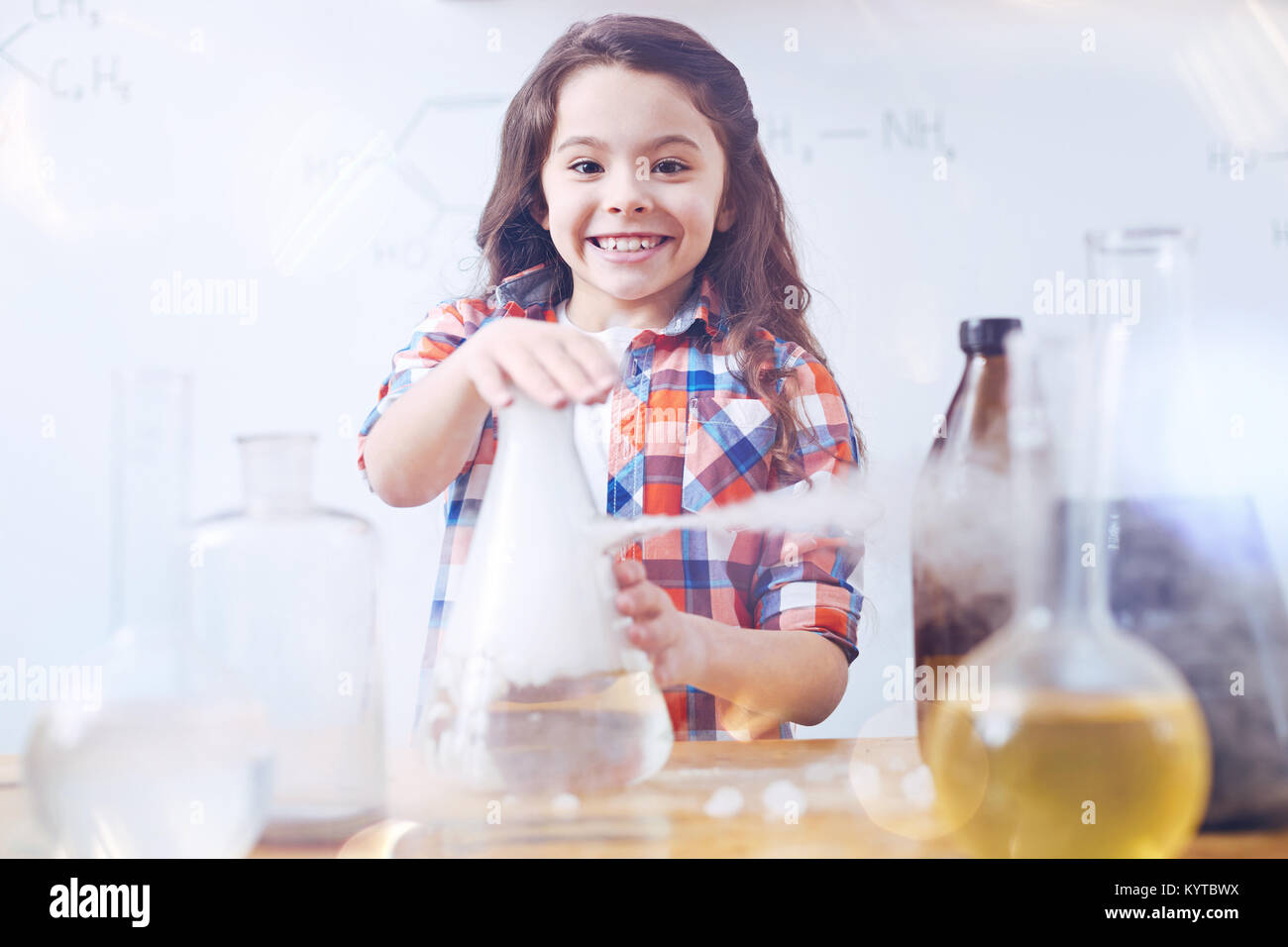 So aufgeregt, neue Dinge zu lernen. Elementare Studentin grinste breit, die während der Arbeit mit einer Chemie und führen ein Experiment während einer Ch Stockfoto