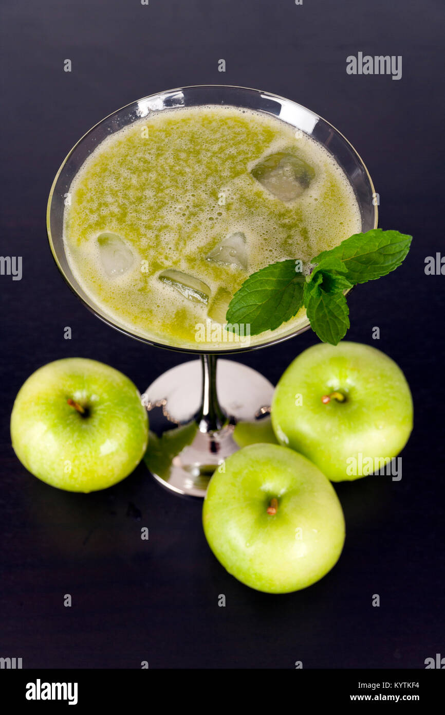 Grüne Früchte und Gemüse juiced in cocktail Glas mit einem Zweig Minze Stockfoto