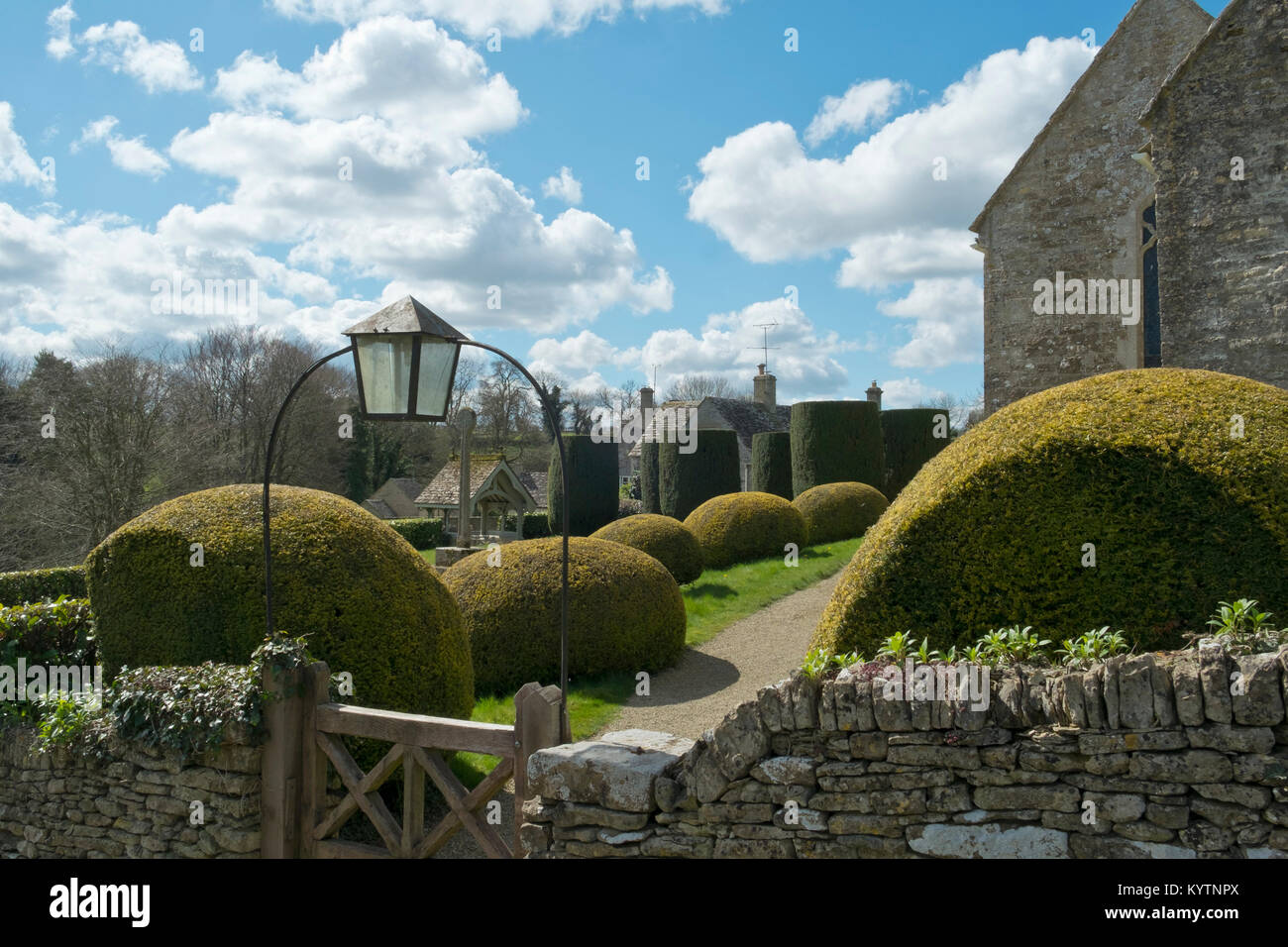 Frühlingssonne auf der malerischen alten Kirchhof bei duntisbourne Äbte in den Cotswolds, Gloucestershire, VEREINIGTES KÖNIGREICH Stockfoto