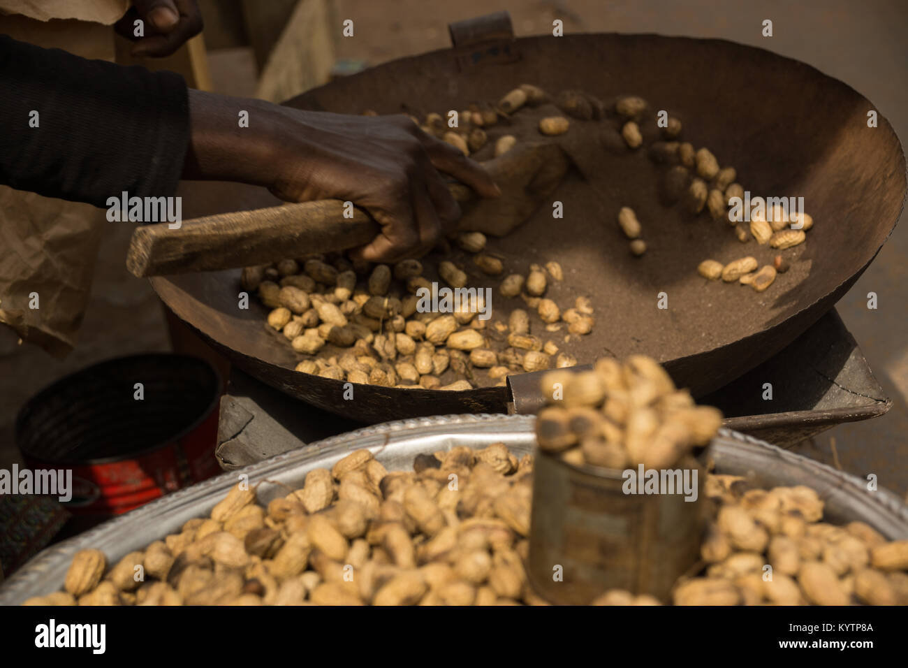 Eine Schale mit Erdnüssen in Serrekunda Markt, Gambia vorbereitet wird. Stockfoto