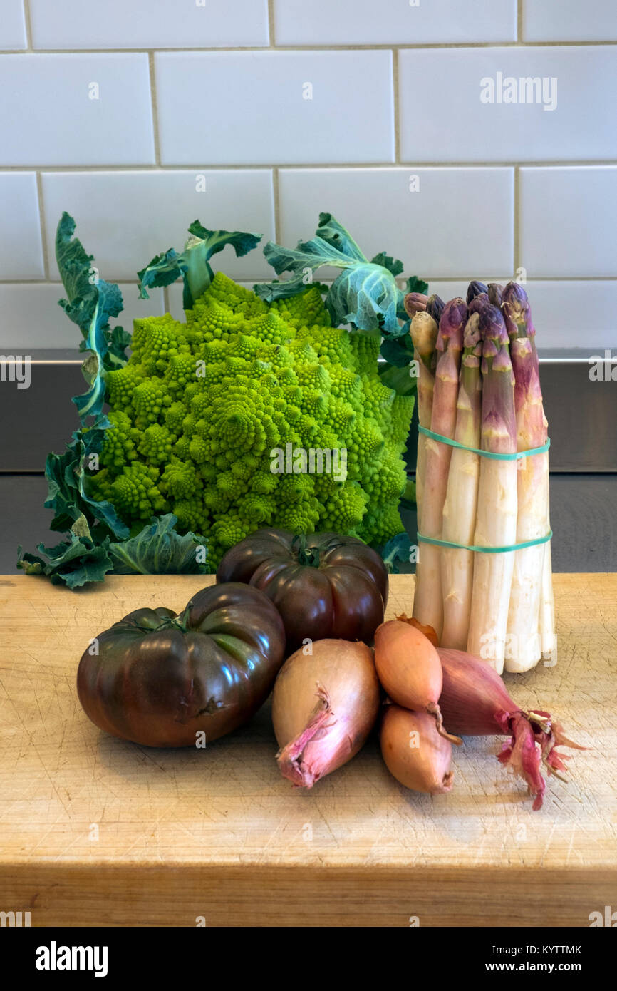 Einige Wahl Gemüse warten auf einem Schneidebrett auf Edelstahl Küche Arbeitsfläche Stockfoto