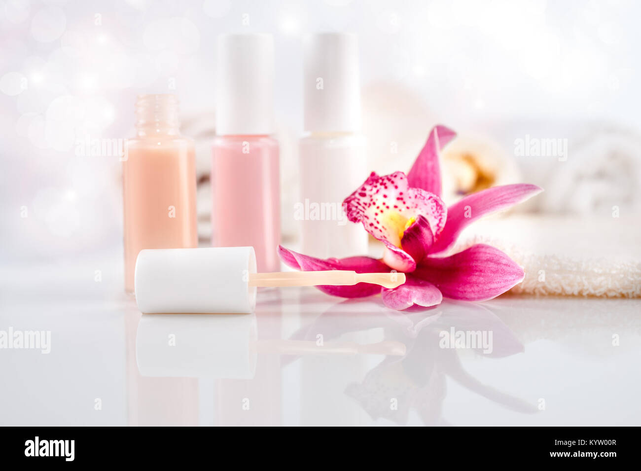 Wellness und Körperpflege Hintergrund. Nagellack, Handtücher und eine einzelne Orchidee Stockfoto
