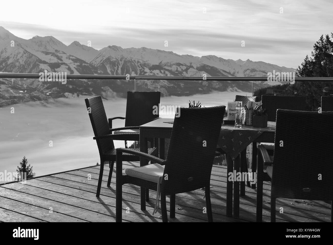 Stühle auf der Terrasse des Cafés in die Berge und die Aussicht auf die Hohen Tauern in der Region Zell am See - Kaprun, im Winter. Österreich, Europa. Stockfoto