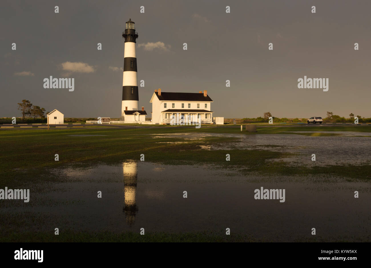 NC-01301-00... NORTH CAROLINA- die Sonne am späten Nachmittag nach einem sehr nassen Tag an Bodie Island Lighthouse in einer Pfütze widerspiegelt; Teil C Stockfoto