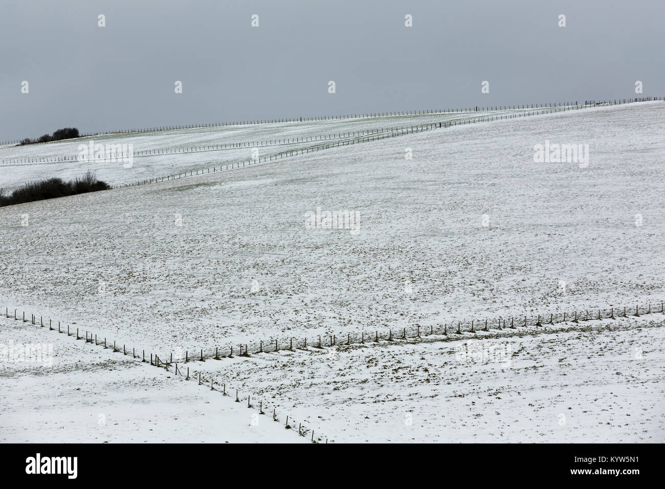 Helles Abstauben des Schnees auf der South Downs in Hampshire. Dunkle, graue Himmel auftauchende Overhead. Stockfoto