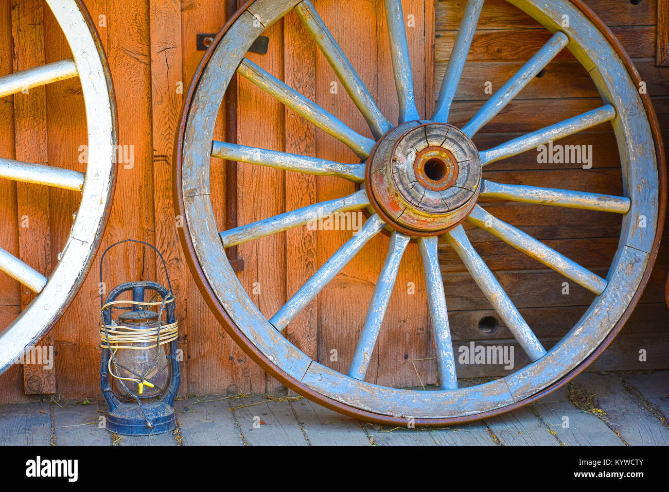 Wild weset Wagen Räder und eine alte Kerosin lanten entlang eines wilden Westen Gebäude aus den 1800er Jahren. Stockfoto