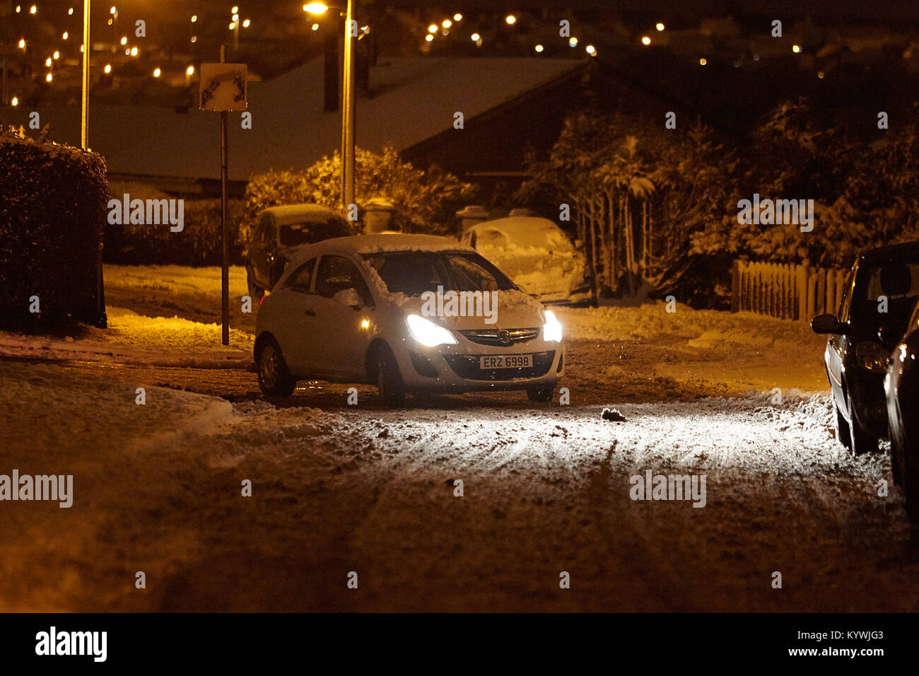 Newtownabbey, Nordirland, Irland. 16 Jan, 2018. Auto Fahrer ins Schleudern fahren durch vorstadtstraße als gelb Wetter Warnung als starker Schneefall beginnt Newtownabbey zu decken außerhalb Belfast, Nordirland, 16. Januar 2018 Credit: Radharc Images/Alamy leben Nachrichten Stockfoto